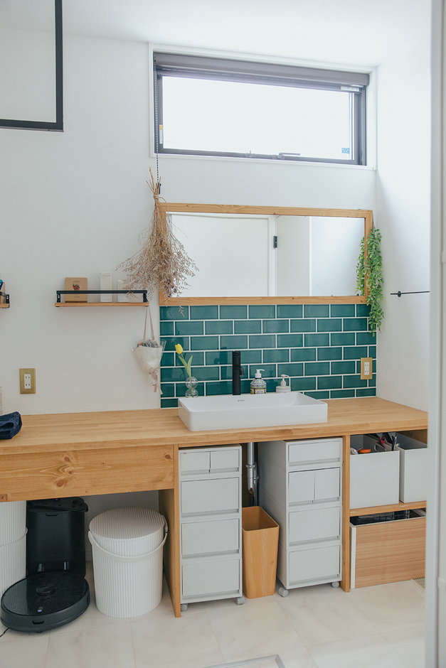 グリーン系タイルと木目の造作カウンターがベストマッチな洗面スペース