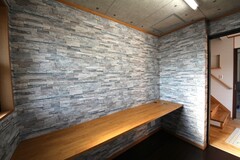 壁面が石材調のデザインクロスで施された木工室。書類などを置けるデスクも備え付け、集中しやすい環境になっています。