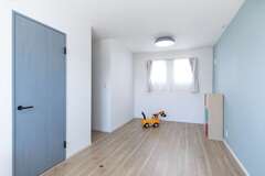 自由にアレンジできるようシンプルにまとめた子ども部屋は、成長に合わせて2つに分割できる造りに。ドアを出たところに、家族共用のファミリークローゼットが用意されている【ぽっくハウス静岡（東海ハウス）】