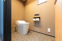 落ち着いた色合いでまとめた、シックなトイレ空間。
床材には表情のある素材を採用し、さりげない個性をプラス。【丸宗建設】