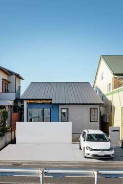 平屋に見える大屋根の外観。塀のうしろには庭とテラスが【tact design firm】