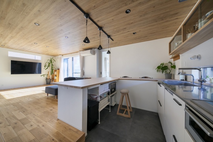 明るい日差しが差し込むモダンなキッチン。カウンター付きで、広々としたスペースが調理を楽しくさせる。収納棚も多数あり機能的