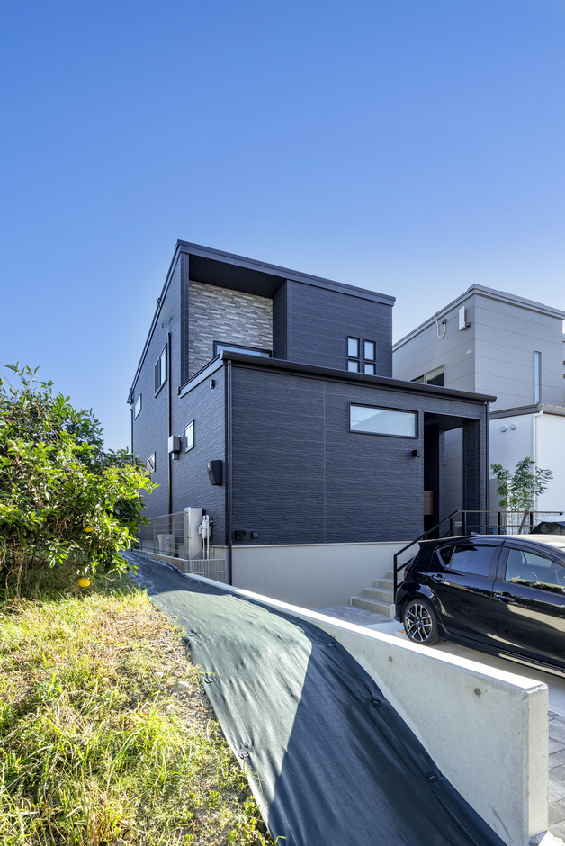 モダンなデザインの二階建て住宅の外観。シンプルでありながら存在感を放ち、周囲の環境と調和した美しさを持つ。【くふうイエタテ】
