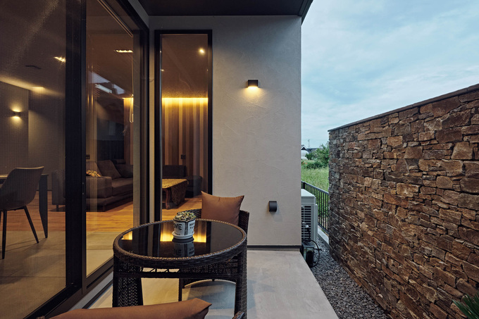 ダイニングの外に設けたタイルデッキ。ガビオンの塀を設けて周囲からの視線を遮り、プライベート感あふれる空間が実現