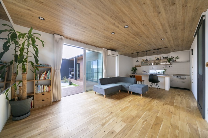 ナチュラルな木目調の床と天井が印象的なLDKスペース。大きな窓からは庭を見ることができ、開放感が感じられる設計。多機能な部屋を実現