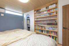 寝室には地震でも倒れてこない造り付けの本棚を設け、大好きな漫画や文庫本をどっさり並べた。寝る前の時間も楽しめる【ぽっくハウス静岡（東海ハウス）】