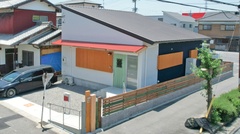 モダンでシンプルな外観が魅力の一戸建て。木材と金属が調和し、シックな印象を与えている。【明城】