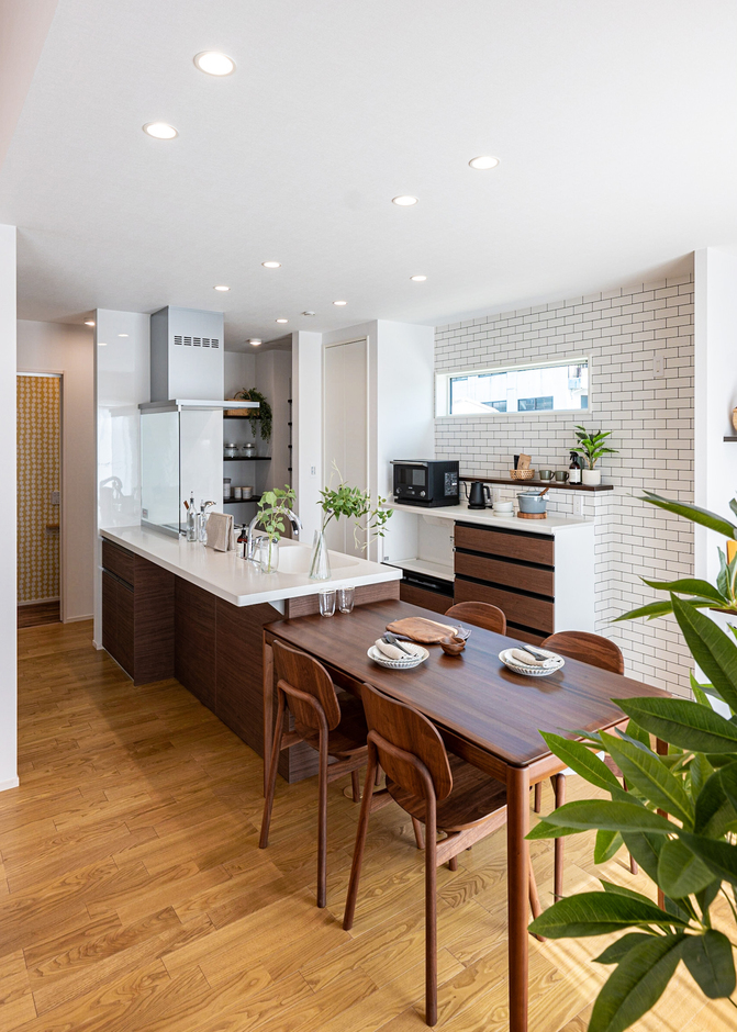 朝の光を採り入れるために東面に窓を設けた、明るく清潔感あふれるキッチン。白のタイル風クロスが光るさわやかな空間で、家族の会話も弾む