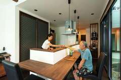 親世帯は、カウンター一体型のダイニングを中心に、和モダンスタイルにコーディネート。ライトアップされた中庭を見ながら晩酌を楽しむ