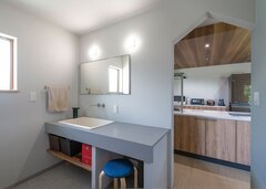 造作の洗面台に深底の医療用シンクをプラス。三角屋根の形状をしたかわいい垂れ壁はママ友からも大好評