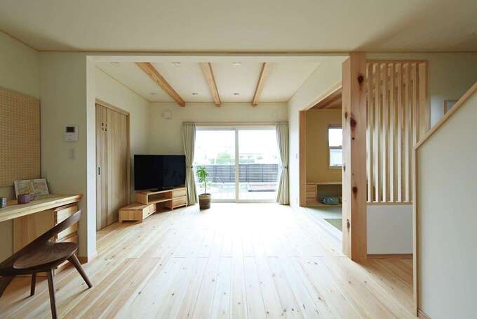 キッチンからはウッドデッキまで視線が抜け、開放感抜群。壁の一部はご主人のアイデアで格子に変更。和の意匠と明かり取りのポイントに