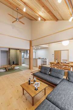 勾配天井の最上部は天井高約5m。LDK＋和室の大空間の中央で欅（ケヤキ）の大黒柱が存在感を放っている