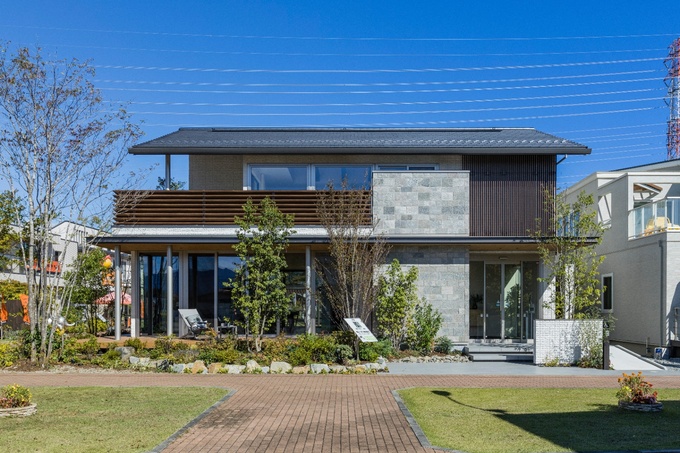 近代的なデザインが際立つ二階建て住宅の外観。広々とした庭が、住まいにゆとりをもたらす