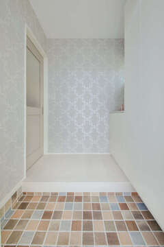 土間のタイルやクロス選びにこだわった玄関。奥さまのセンスが反映されている