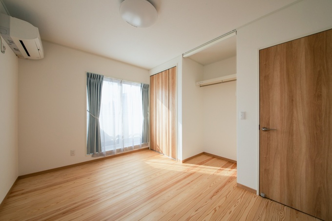 柔らかな木目調の床と大きな窓が特徴の子ども部屋。明るい自然光が入る設計で、成長を見守る温かい空間が整う。