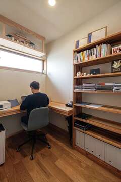 ご主人の書斎。デスクはL字型に。仕事柄資料が増えてしまうが、充分な収納力がある造作棚のおかげですっきりとした空間を保つ【藤田工務店】
