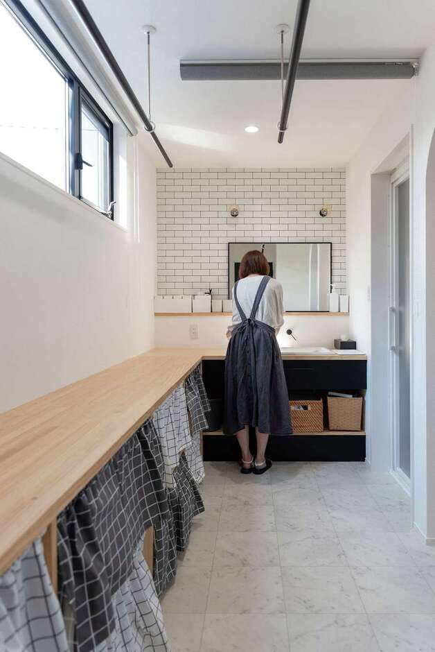 洗面脱衣所とランドリールームを兼ねた、贅沢な広さの家事室。洗う、干す、畳むがここで完結。畳んだ洗濯物は家事室に隣接のファミリークローゼットへ