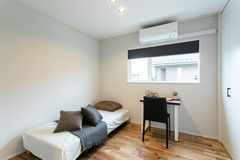 シンプルで機能的な子ども部屋。コンパクトなデスクスペースがあり、学習環境にも適している。ナチュラルな木目調の床が温かみを感じさせる。