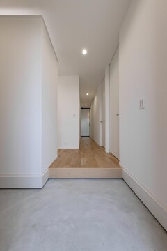 シンプルでモダンなデザインの廊下。明るい木目の床材が空間を広く見せ、スッキリとした印象を与える。【PG HOUSE（ピージーハウス）】