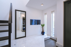 玄関横は水槽が良く見えるように壁に開口が設けられている。姿見を兼ねたドアの向こうはご主人の趣味室で、その中に水槽が設置されている。