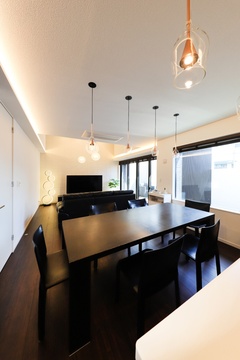 モダンなダイニングルーム。シックな木製のテーブルと椅子が落ち着いた雰囲気を演出。ペンダントライトが空間に温かさを添えている。