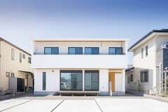 白い外壁にレッドシダーの軒天がアクセント