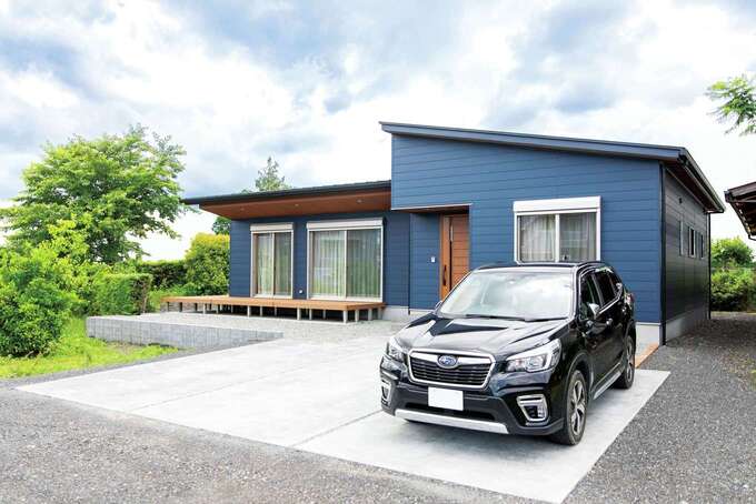 外壁に用いられた金属サイディングのブルーと、デッキや軒天のブラウンが調和した外観