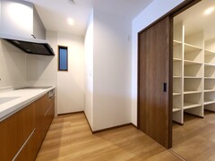 シンプルで機能的なキッチン。背面は料理をしながらパントリーへ行き来できる動線に。