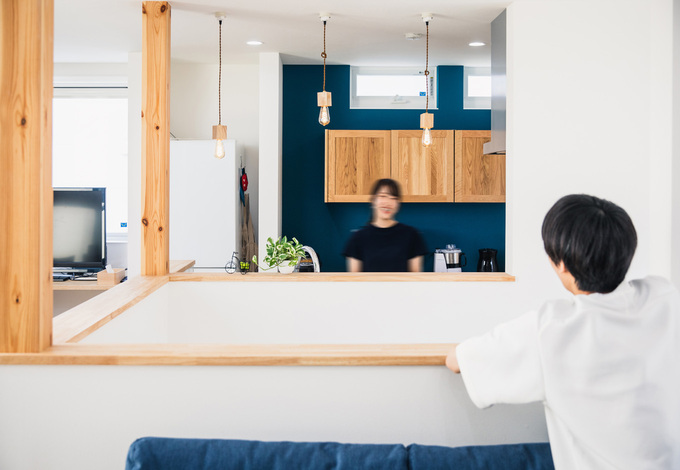 吹抜けの階段ごしに、アイランドキッチンとリビングを向かい合わせに配置した間取りは、他の家にはなかなかないユニークなシチュエーション。程よい距離がそれぞれの空間に落ち着きをもたらしている。調理をしながら会話も楽しめる