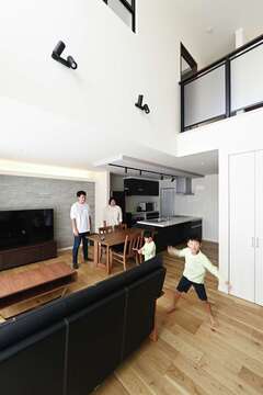 ソファや階段の手すり、照明などに黒を用いてメリハリを効かせたシンプルモダンなLDK。子どもたちがのびのびと遊ぶ様子をどこからでも見守れる