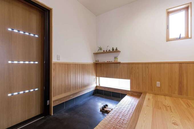 家の顔となる玄関は、広さと明るさを重視。木の腰壁は、喫茶店の内装を参考にしたそう