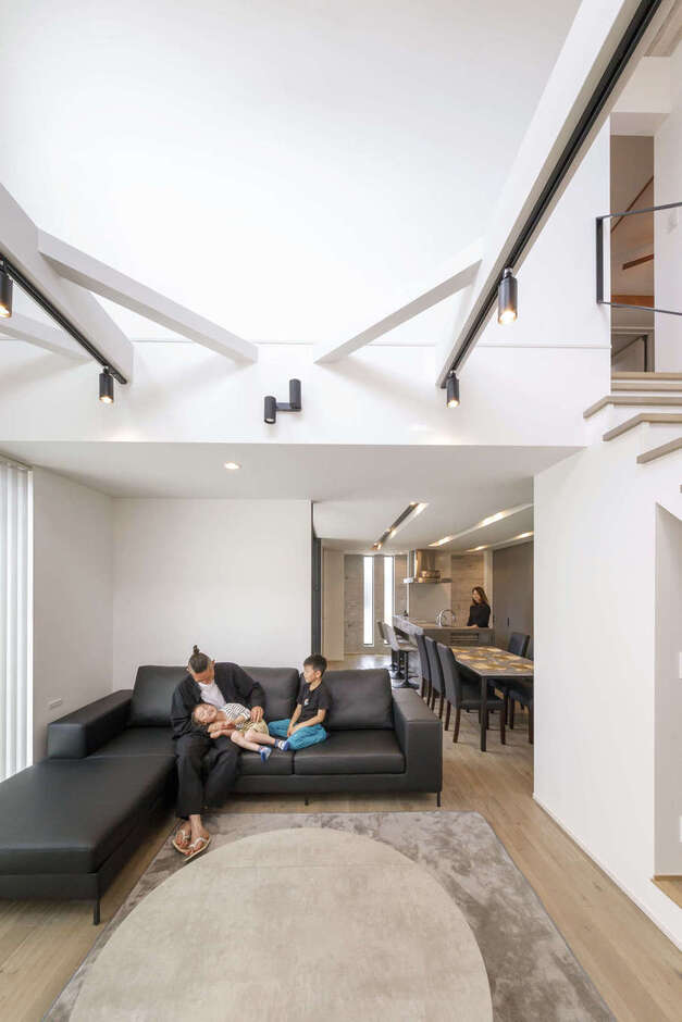 26畳の大空間LDK。吹抜けのあるリビングは開放感に満ち、時間の流れがゆっくりと感じられる。ダイニングとリビングは、つながりを持たせながらゆるやかにゾーニングし、空間にメリハリをつけた。非日常のリゾートの薫りが日常に広がる、特別な住まいが実現した