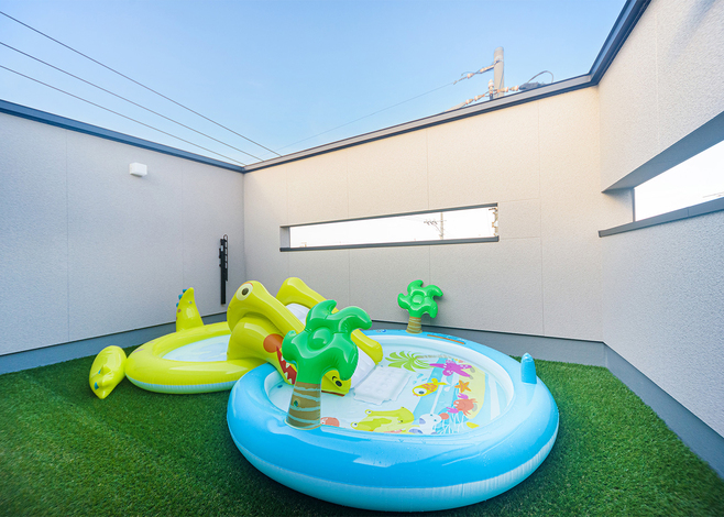 屋上バルコニーには人工芝を敷いて子どもの遊び場に。夏はプールで水遊びやおうちキャンプなど、周りの視線を気にせず思いっきり屋外遊びができる。子どもも大好きな場所