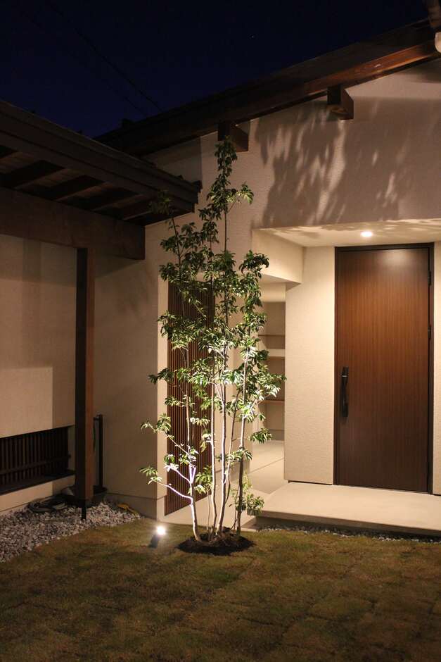 温かみのあるライトアップが印象的な夜の外観。シンプルなたたずまいが、落ち着いた雰囲気を演出している。