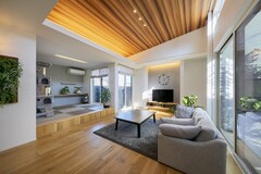 明るい自然光が差し込むLDK空間。木目調の天井が温かみを演出し、開放感あるリビングとダイニングが一体化しています。