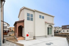 シンプルで洗練されたデザインの住宅外観。大きな窓と落ち着いた色合いの外壁が特徴で、周囲の風景に溶け込む美しい佇まい。【ハレノイエ （中村土建）】