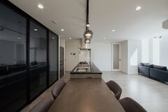 キッチン背面には収納兼パントリーを用意した。来客時は透過性のあるブラックの引き戸で目隠し【アイ工務店】