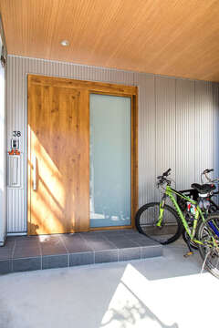 LDKに合わせたことで広くなった玄関の軒先を利用して自転車置き場も確保。外から見えにくく、雨にも濡れないので安心。キャンプ用品などを洗った後も干しておけるゆとりの空間