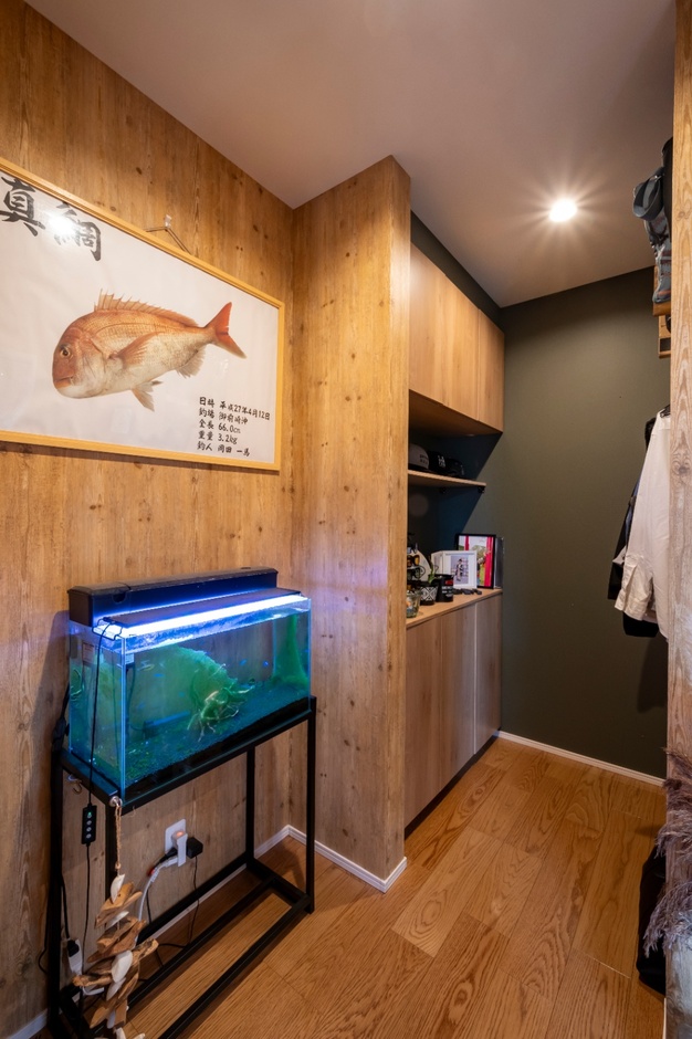 木目調の壁と水槽がおしゃれな玄関ホール。落ち着いた雰囲気で来客を迎えるのにふさわしい空間。