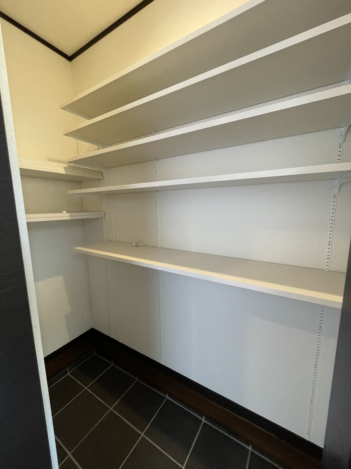 十分な棚スペースを備えたシューズクローク。靴や小物を整然と収納できる機能的なデザインが特徴である。