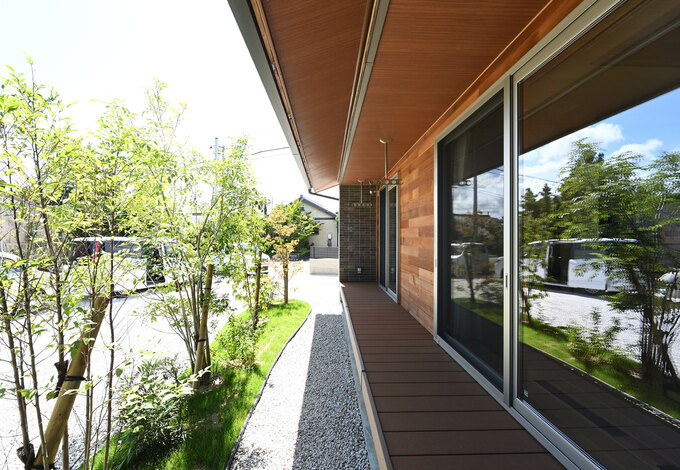 深い軒が夏の直射日光を遮り、太陽高度の低い冬は、室内の奥まで光を届ける。落葉樹と広葉樹を交互に植えるなど、先人の知恵と自然エネルギーを巧みに活かしたパッシブデザインを採用。縁側のようなウッドデッキでビールを飲むのが至福のひととき