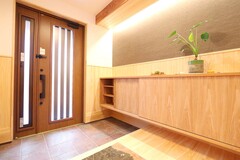 木のぬくもりあふれる玄関。間接照明が自然素材を柔らかに照らす【エコフィールド】