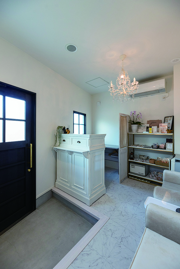 フレンチアンティークのシックな設えのサロン。憧れのシャンデリアが似合う空間。床は大理石調のパネルで高級感も演出