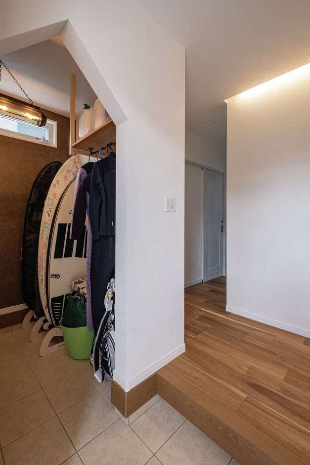 サーフボードもウエットスーツもすっぽり収納できる大容量の玄関クローゼット。三角屋根の形をした垂れ壁がアクセントに