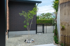 小石が敷かれたスペースには緑が映え、自然が感じられる癒しの空間を創出している。