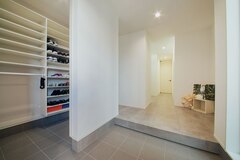 玄関には機能的なシューズクロークを設けた。来客時は扉で隠してスッキリ。正面の動線は洗面を経由し、脱衣室や寝室へと続く【アイ工務店】