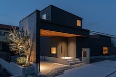 シックなカラーリングの2階建て住宅の外観。夜のライトアップが美しく、落ち着いた雰囲気を醸し出している。【ARRCH アーチ】