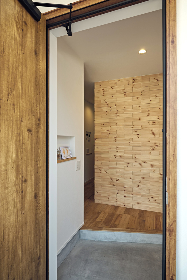 玄関正面には無垢板のデザインパネルを採用