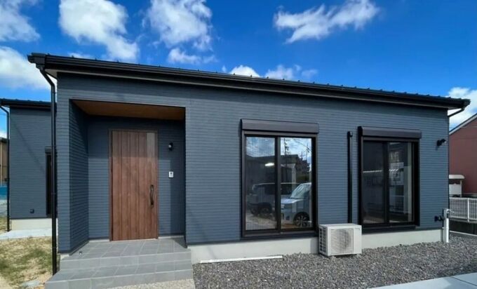 モダンなデザインのシンプルで機能的な平屋の外観。落ち着いた色合いの壁材が用いられ、洗練された印象を与える。