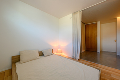 シンプルで落ち着いた雰囲気の寝室。ナチュラルな照明が心地よい空間を演出し、リラックスできる。